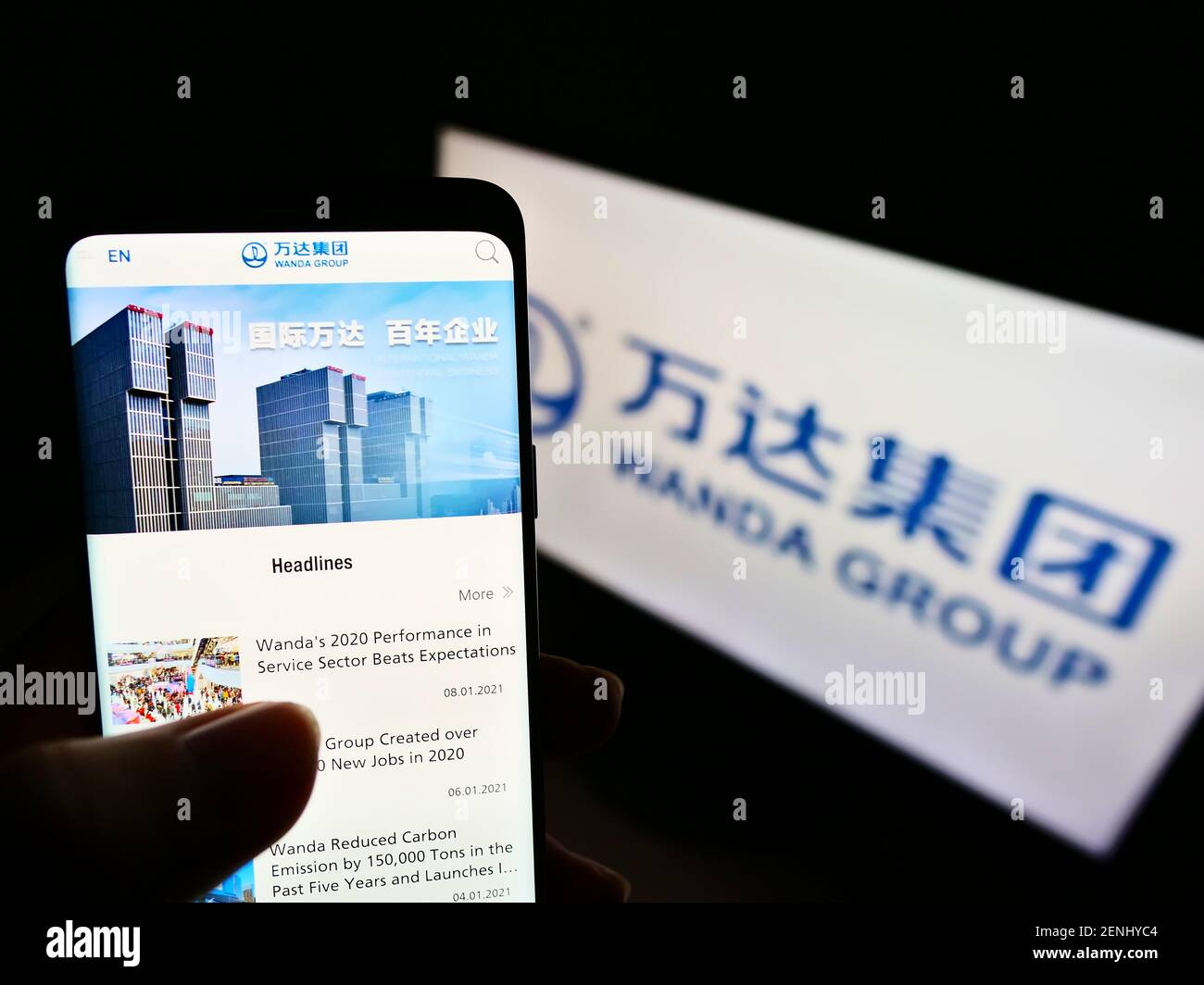 Personne tenant un téléphone mobile avec le site Web du conglomérat chinois Dalian Wanda Group sur l'écran devant le logo. Concentrez-vous sur le centre de l'écran du téléphone. Banque D'Images