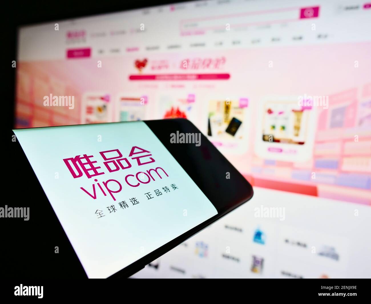 Smartphone avec le logo de la société chinoise Vipshop Holdings Ltd (boutique en ligne VIP.com) sur l'écran en face de la page Web. Concentrez-vous sur le centre de l'écran du téléphone. Banque D'Images
