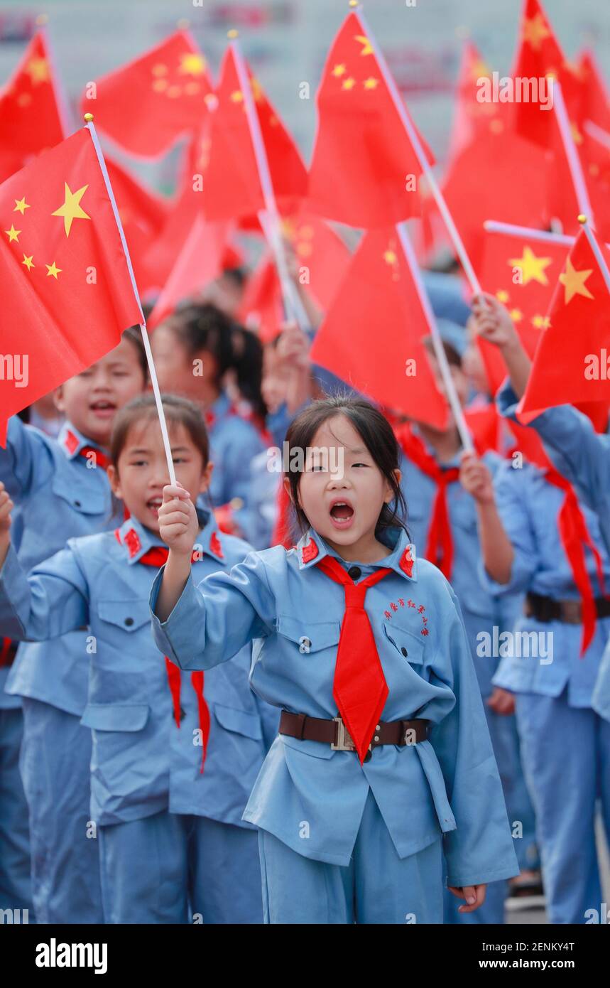 Les jeunes étudiants chinois portant les uniformes de l'Armée rouge et les foulards  rouges des jeunes pionniers de Chine jurent et crient des slogans alors  qu'ils brandirent les drapeaux nationaux chinois lors
