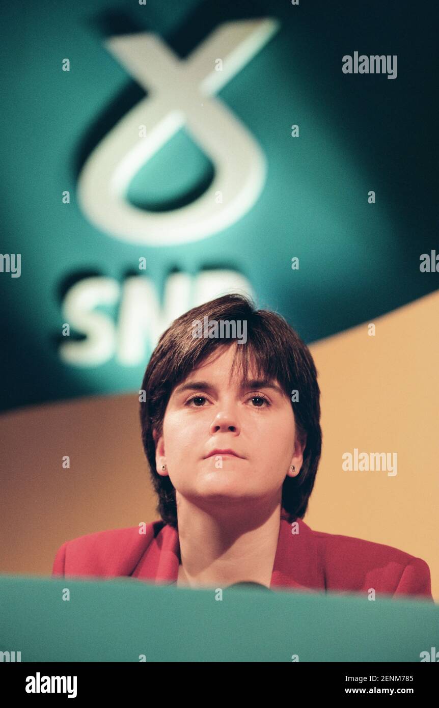 Nicola Sturgeon, du Parti national écossais, écoutant le chef de son parti, Alex Salmond, s'adresser aux médias lors du lancement du manifeste 1999 du SNP pour la campagne électorale de Holyrood à Édimbourg, en Écosse. Mme Sturgeon a été élue au Parlement écossais nouvellement créé en 1999 et a continué à servir comme premier ministre adjoint du pays sous la direction d'Alex Salmond MSP, puis comme premier ministre. Au moment de l'élection de 1999, elle travaillait comme avocate au DrumChapel Law and Money Advice Centre de Glasgow. Banque D'Images