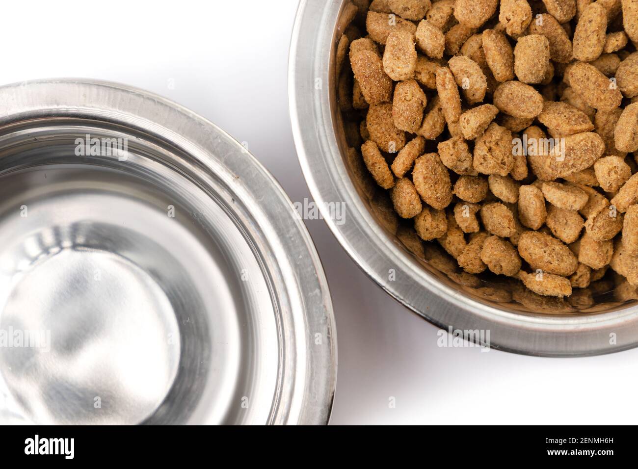 séchez la nourriture pour animaux et l'eau potable dans un bol en fer isolé sur fond blanc Banque D'Images