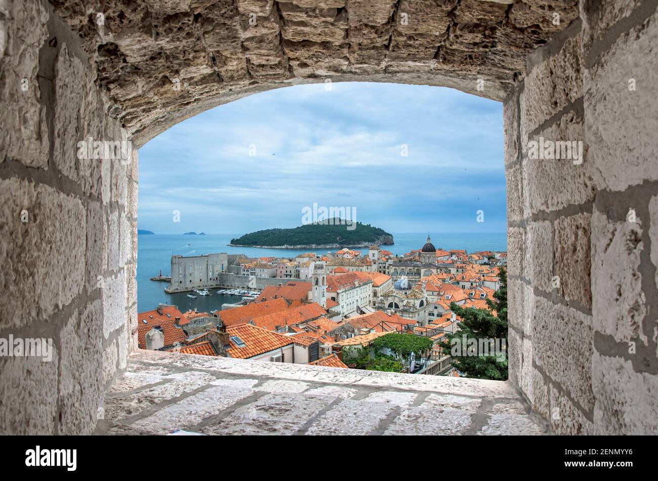 Vue depuis la fenêtre en pierre des toits rouges et de la forteresse dans le vieux Dubrovnik. Belle vue sur la mer bleue, l'île et le vieux centre historique de Dubrovnik, C Banque D'Images