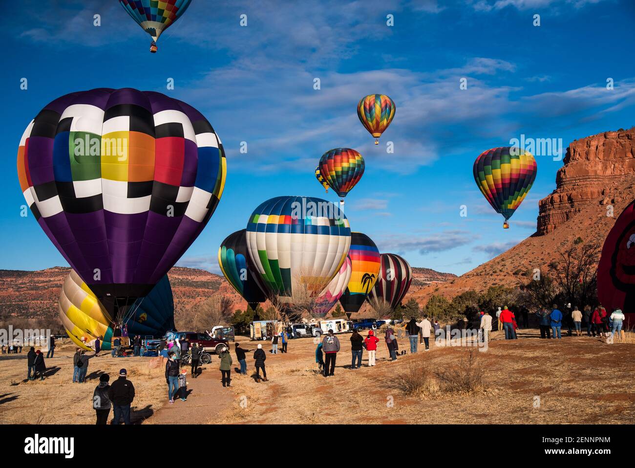 Kanab, Utah, États-Unis, 19 février 2021 - des spectateurs se rassemblent pour observer 30-40 ballons d'air chaud s'élever au-dessus des falaises rouges et du ciel bleu de Kanab, Utah, États-Unis. Banque D'Images