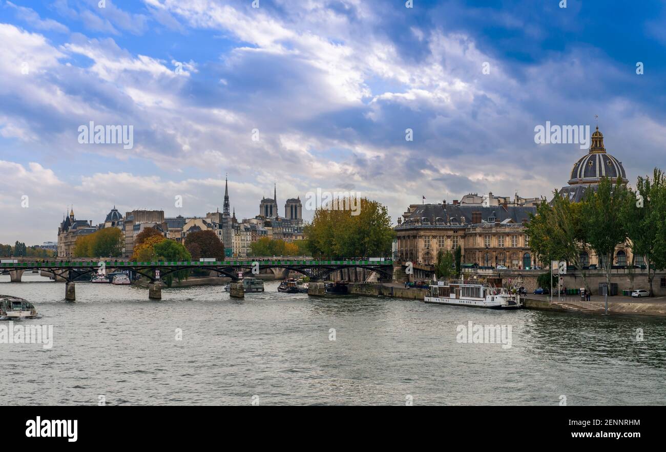 Les quais de la Seine, le Pont des Arts et la Cathédrale notre Dame au loin à Paris, France Banque D'Images