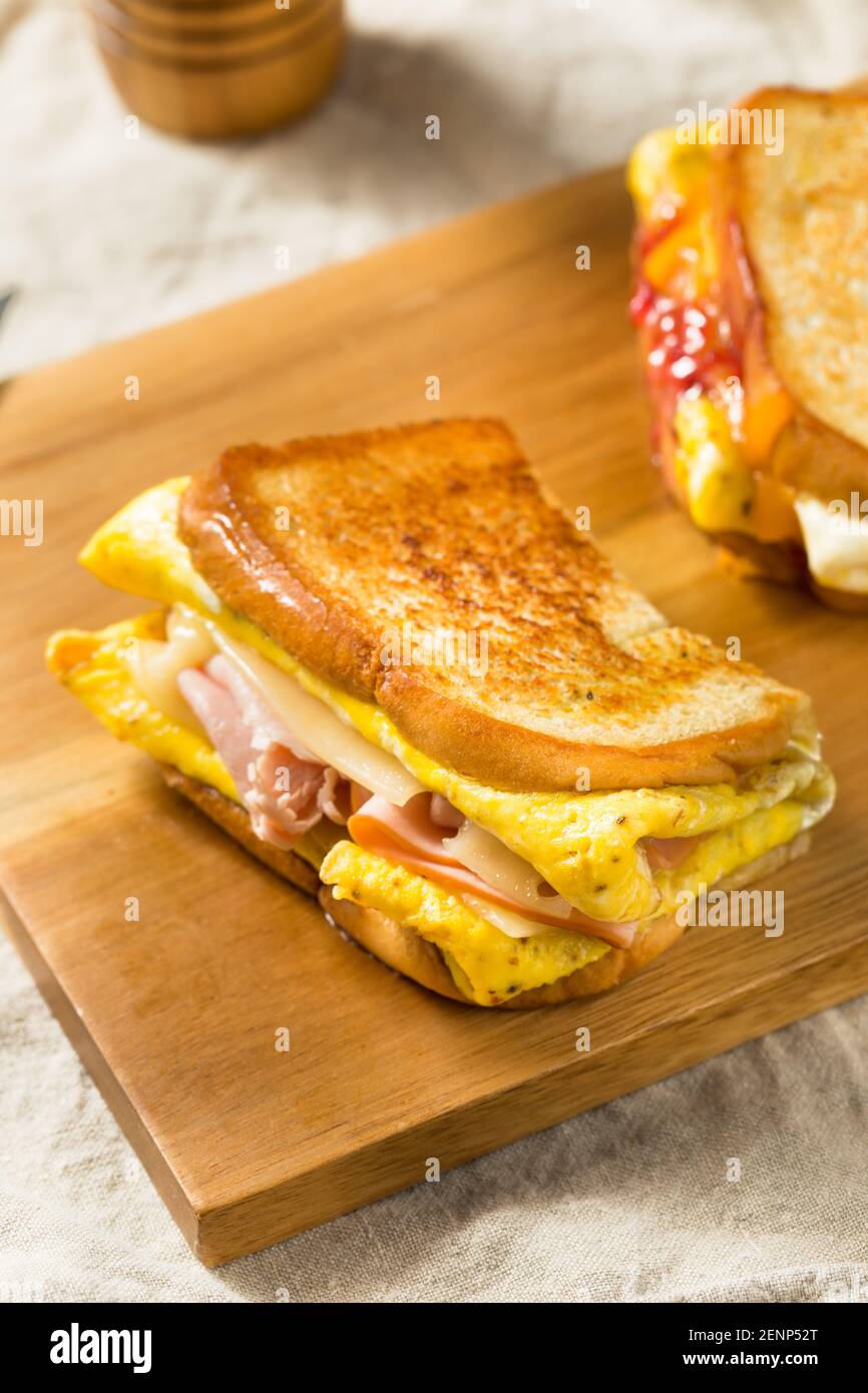 Sandwich-déjeuner fait maison avec un poêle à œufs, jambon, fromage et Bourrage Banque D'Images