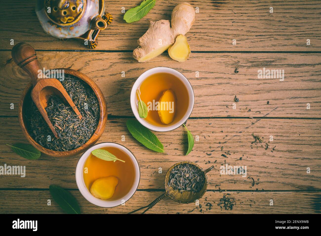 Thé au gingembre avec feuilles de sauge et feuilles de thé noir séchées sur fond en bois Banque D'Images