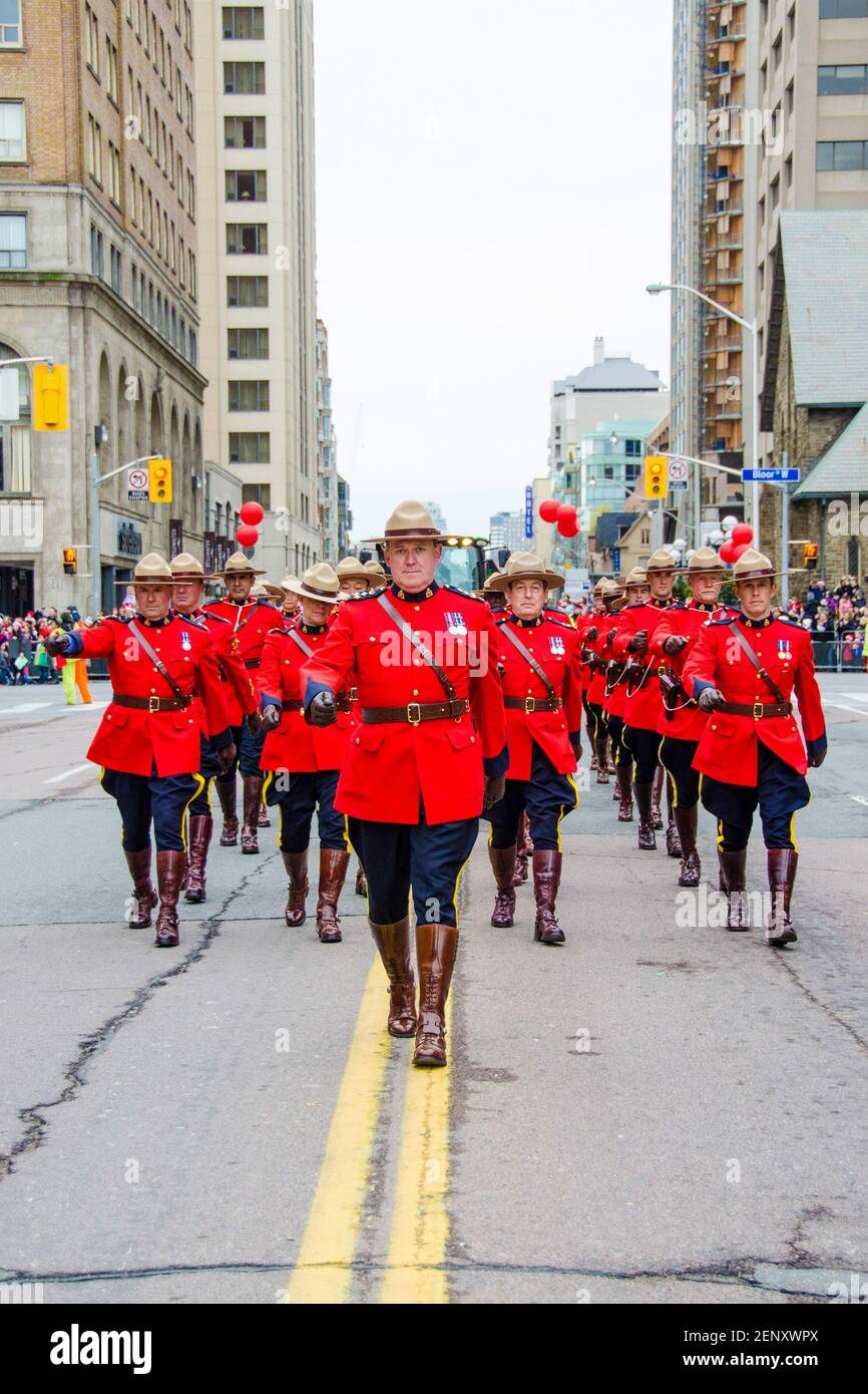 La police montée canadienne ou les Mounties défilent à la célébration de la 109e édition de la Parade du Père Noël. Plus d'un demi-million de personnes y participent Banque D'Images