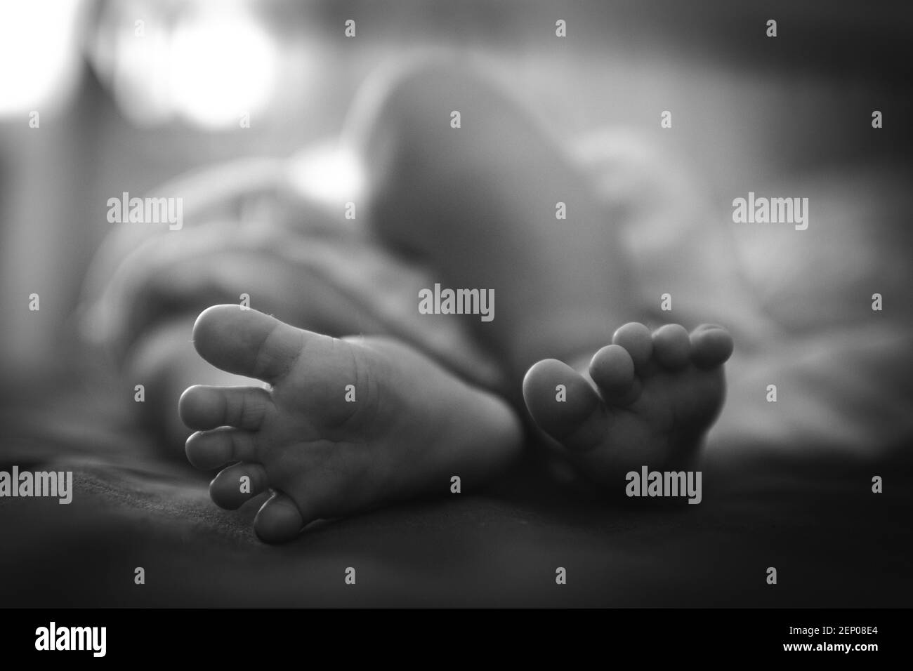 Une photo noir et blanc d'un nouveau-né pieds dedans la chambre Banque D'Images