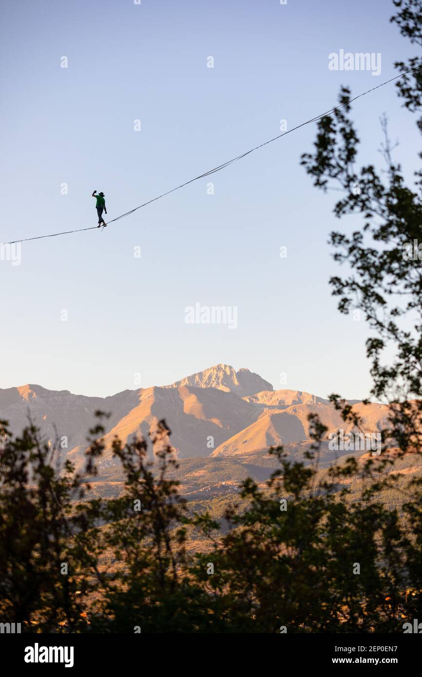 Slackliner qui se promore sur Gran Sasso avec des arbres au premier plan Banque D'Images