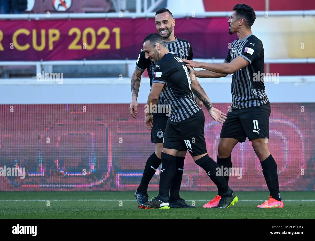 Doha, Qatar. 26 février 2021. Bagdad Bounedjah (R) d'Al Sadd SC fête avec ses coéquipiers après avoir marquant le but d'ouverture lors du match final de la coupe du Qatar entre Al Sadd SC et Al Duhail SC à Doha, Qatar, le 26 février 2021. Credit: Nikku/Xinhua/Alay Live News Banque D'Images