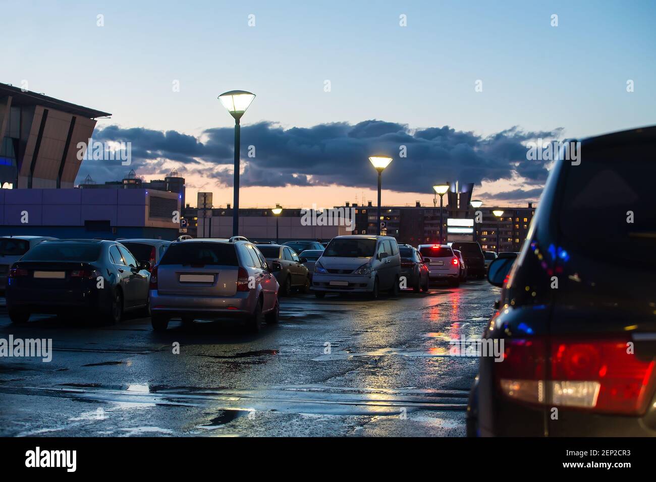 Voitures dans la ville dans le parking la nuit sous la pluie Banque D'Images