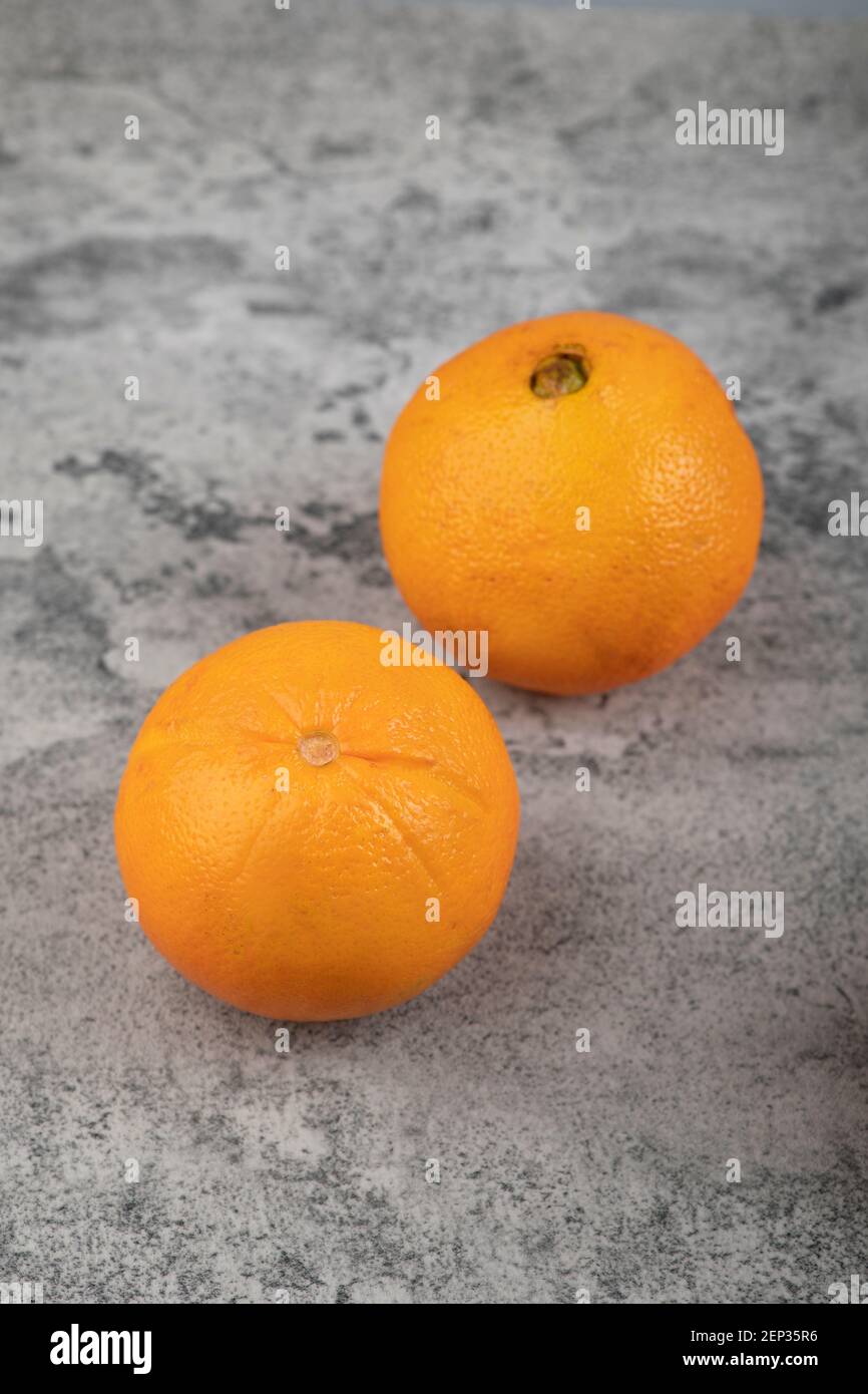 Deux fruits orange frais isolés sur une table en pierre Banque D'Images