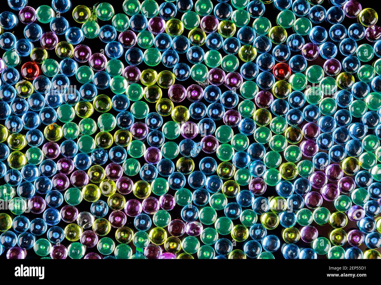 Galets en verre multicolore comme arrière-plan. Perles en forme de bol à poisson. Banque D'Images