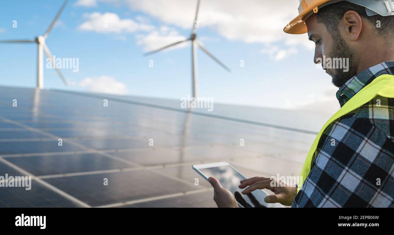 Jeune homme travaillant avec une tablette numérique dans une exploitation d'énergie renouvelable - Eco et concept de technologie - Focus sur l'oreille Banque D'Images