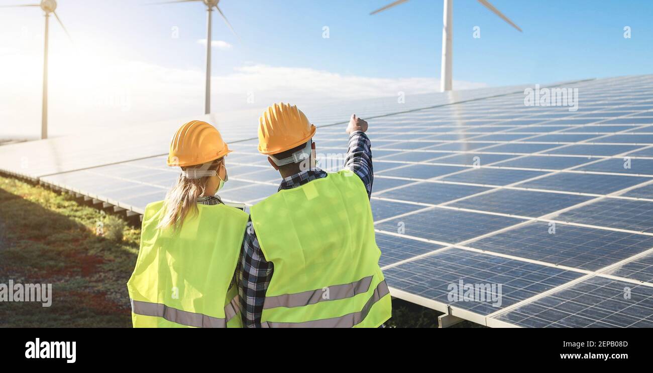 Personnes travaillant pour une ferme d'énergie alternative - énergie éolienne Processus générateurs et panneaux solaires - accent sur les casques Banque D'Images