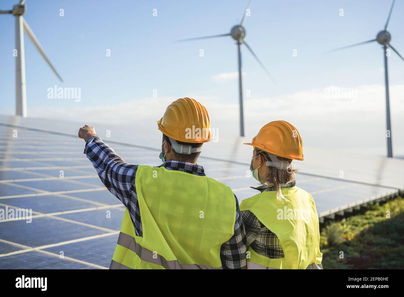 Personnes travaillant pour une ferme d'énergie alternative - énergie éolienne processus des générateurs et panneaux solaires Banque D'Images