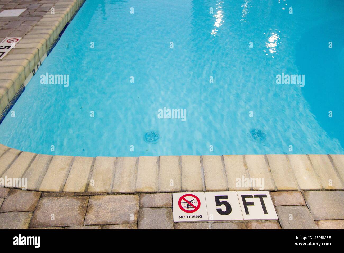 Extrémité peu profonde de la piscine avec panneau d'avertissement indiquant qu'il n'y a pas de plongée. Banque D'Images