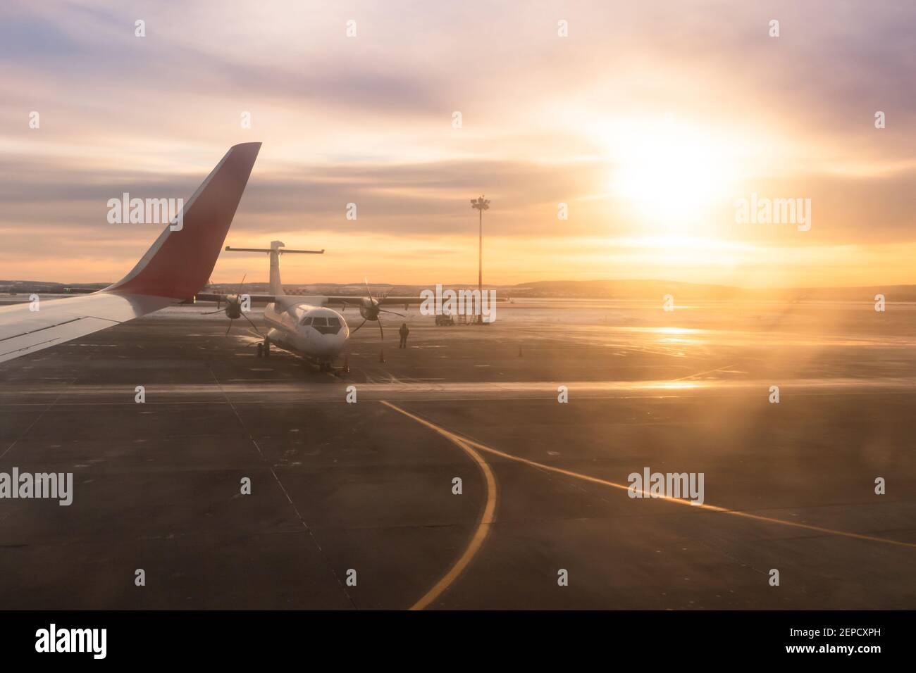 vue depuis la fenêtre d'un avion qui s'envoler sur la piste et le ciel avec des nuages à l'aube. partie d'une aile d'avion dans le cadre Banque D'Images