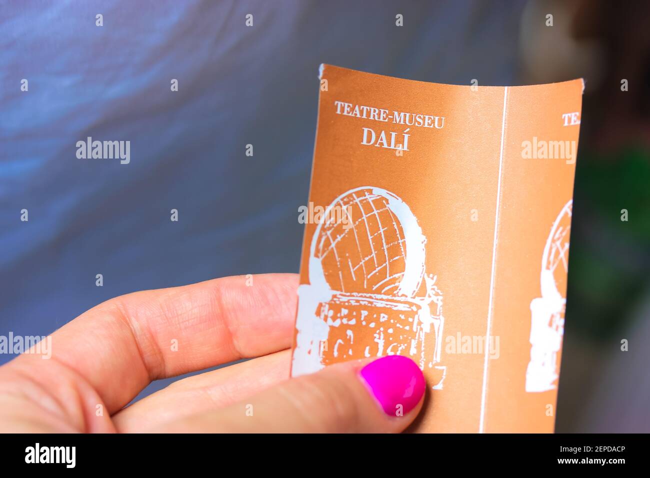 Figueres, Catalogne, Espagne, juin 2019. Le billet orange du théâtre-musée du peintre surréaliste Salvador Dali à Figueres dans la main d'une femme Banque D'Images