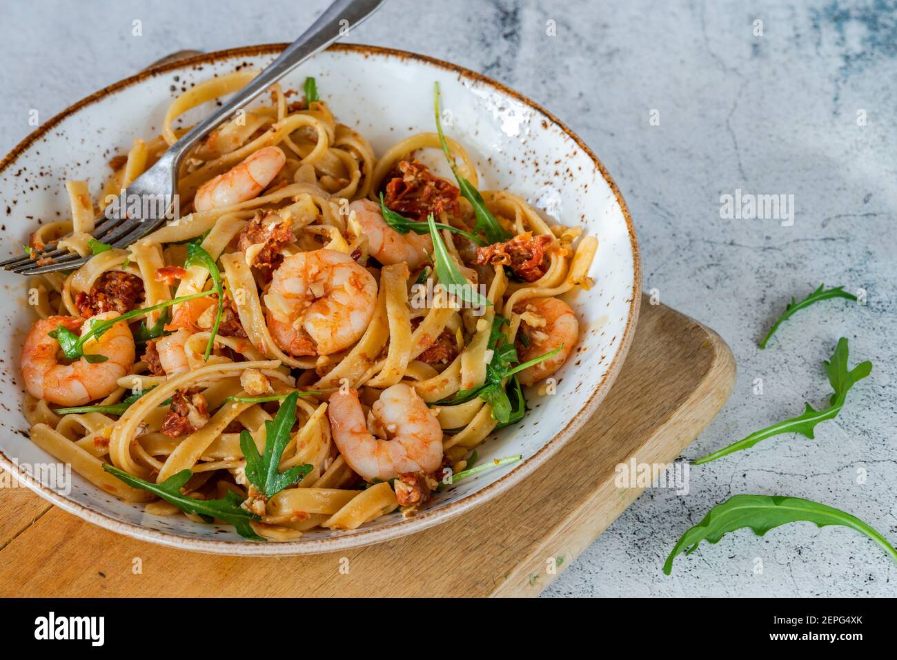 Crevettes tigrées à la tomate, au piment et au pesto aux amandes avec pâtes de fettuccine Banque D'Images