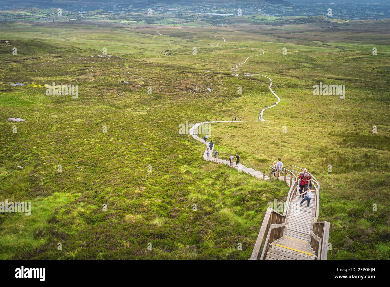 Enniskillen, Irlande du Nord, août 2019 personnes randonnée sur une promenade en bois, escalade sur des marches abruptes et des escaliers pour atteindre le sommet de la montagne Cuilcagh Banque D'Images