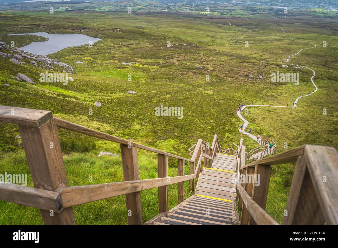 Vue de dessus sur les personnes grimpant sur les marches abruptes et les escaliers de la promenade en bois, pour atteindre le sommet de la montagne Cuilcagh, Irlande du Nord Banque D'Images