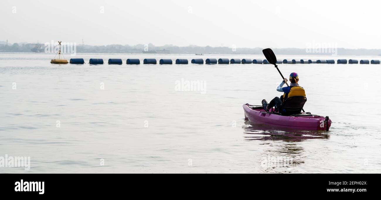 Vue arrière d'une femme en kayak. Pagayer le canoë ou le petit bateau. Kayak, canoë, pagayage Banque D'Images