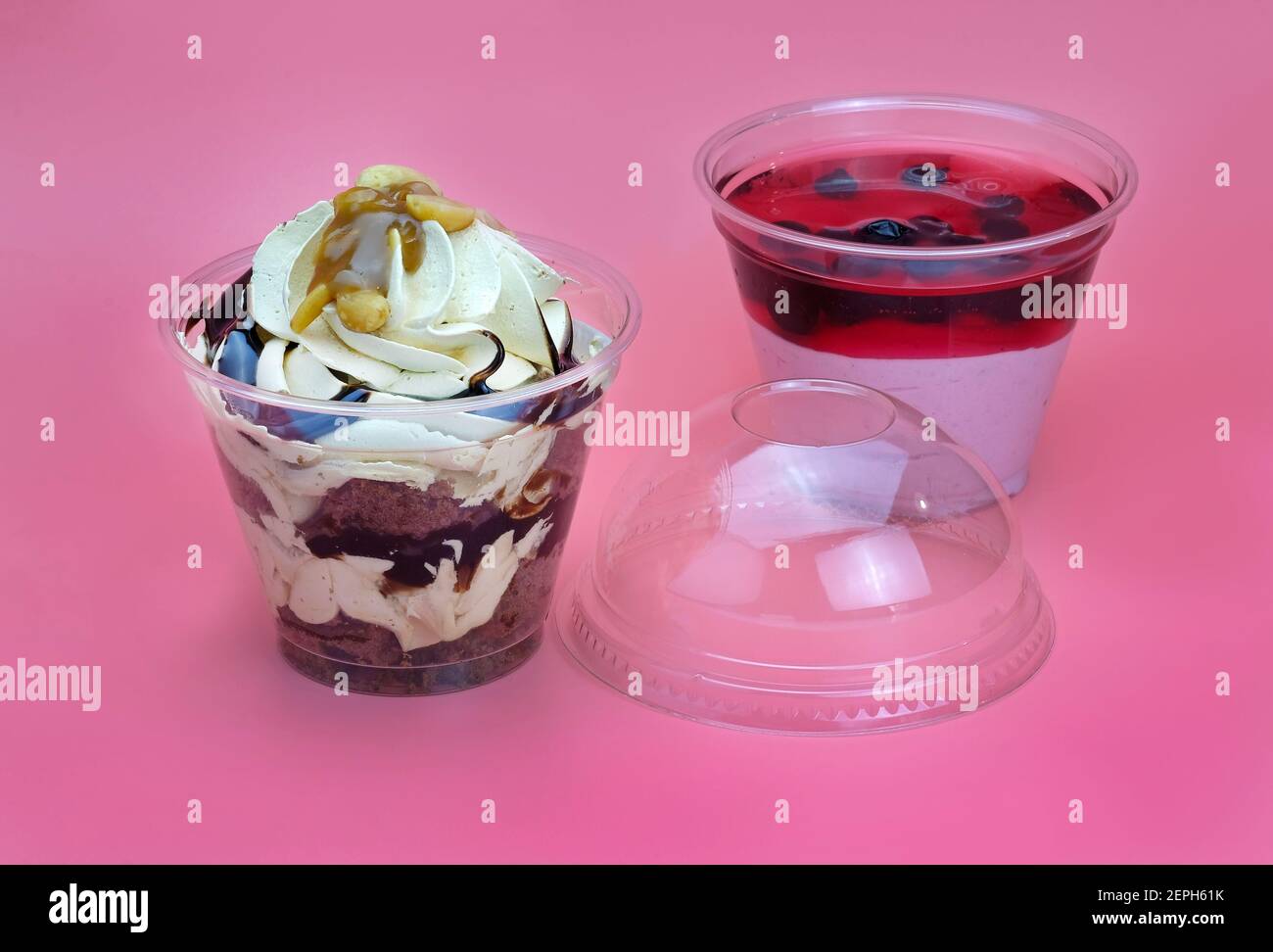 Desserts au chocolat et aux baies dans des tasses en plastique. Dessert à la crème et au chocolat et dessert aux fruits caillé avec gelée. Desserts à emporter au Disdispose Banque D'Images