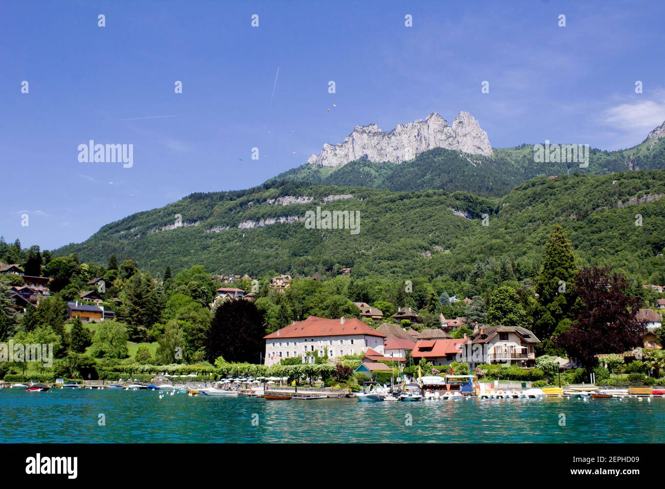 Belle vue sur la jetée et les maisons du village par une journée ensoleillée.Menthon-Saint-Bernard. France. Banque D'Images