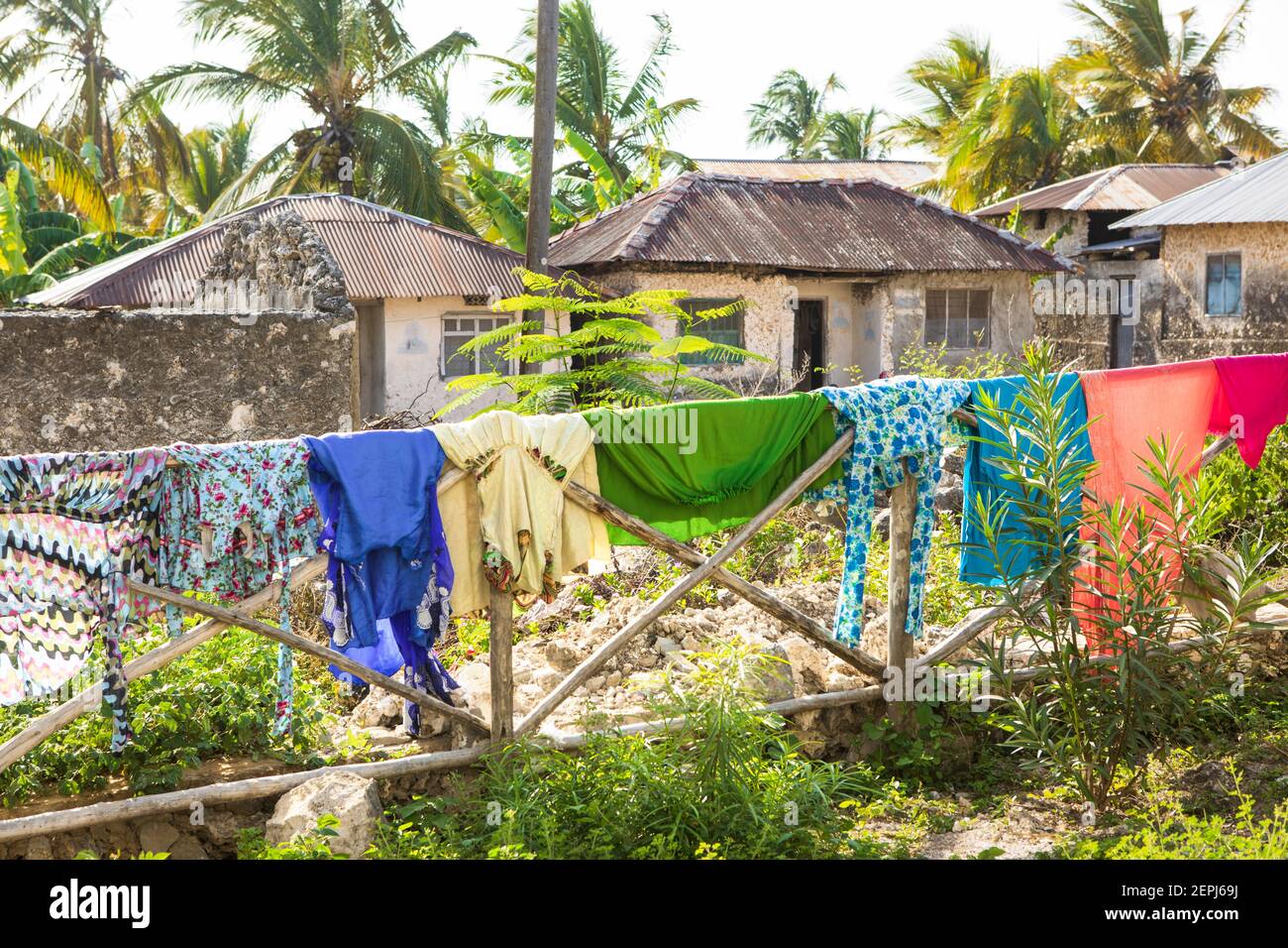 Un lave-linge coloré dans la rue du village africain. Vêtements mouillés vêtements suspendus sur une clôture en bois, climat tropical. Zanzibar, Tanzanie Banque D'Images