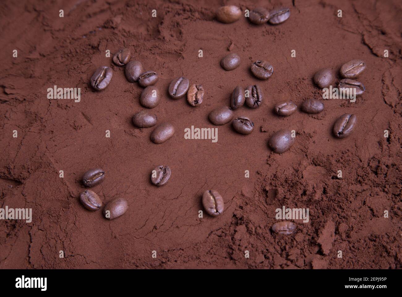 Grains de café éparpillés sur du café moulu torréfié. Banque D'Images