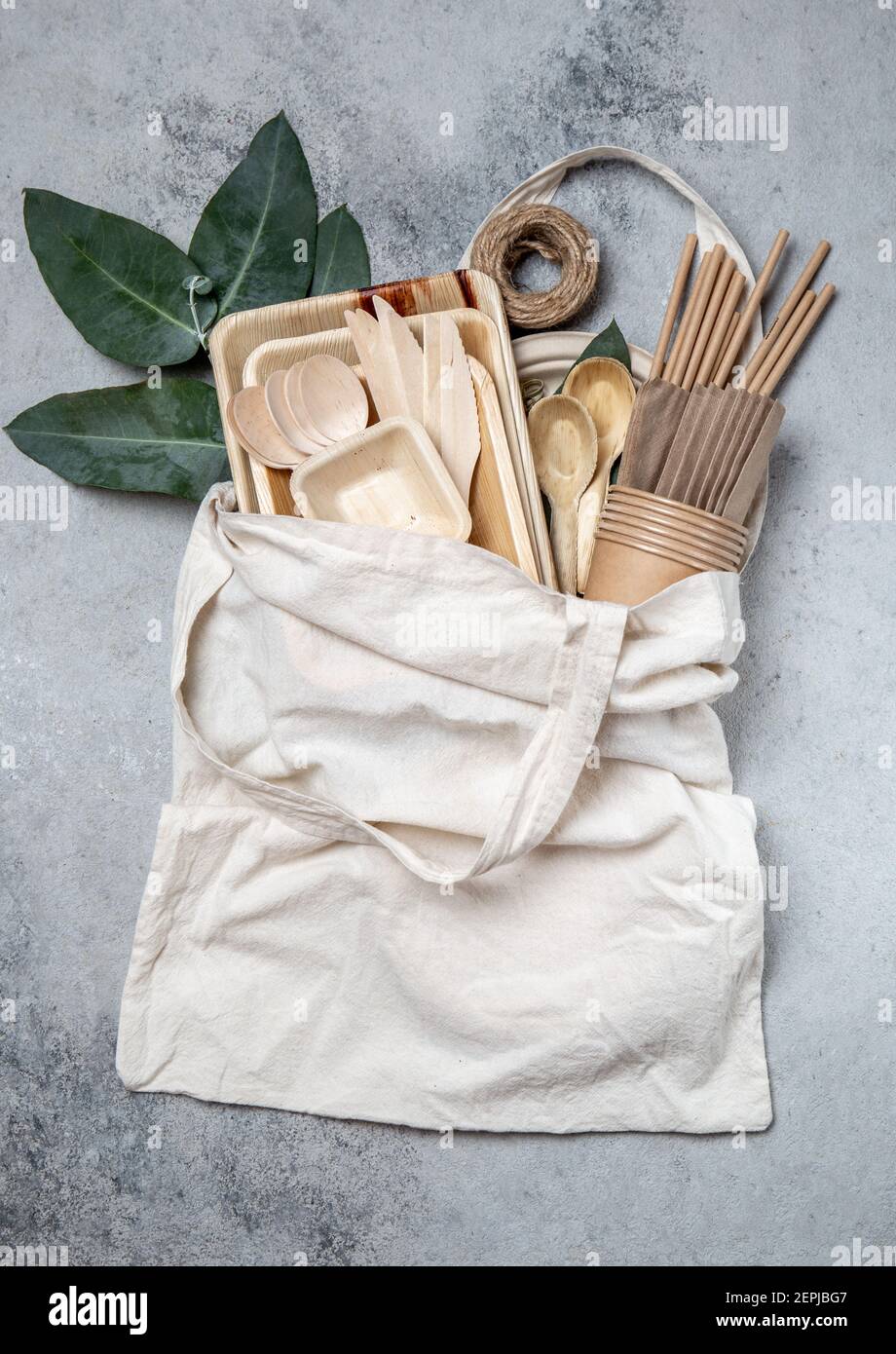 Vaisselle en papier et bois éco-artisanale. Gobelets en papier, vaisselle, sac, assiettes et couverts en bois dans un sac en lin. Recyclage ou concept écologique Banque D'Images