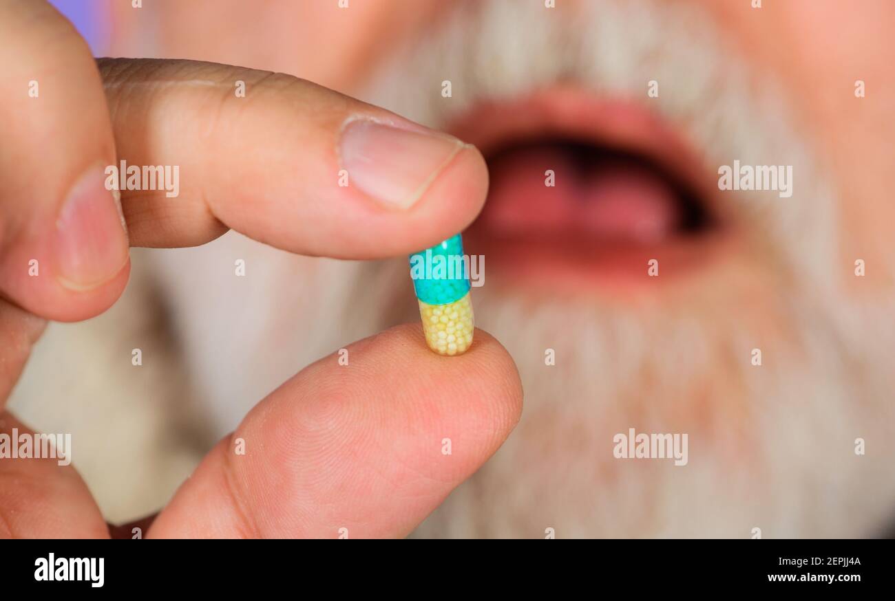 Traitement. Homme avec pilule à la main. Homme prenant des pilules pharmaceutiques. Santé et médecine. Médicament et antidépresseur. Banque D'Images