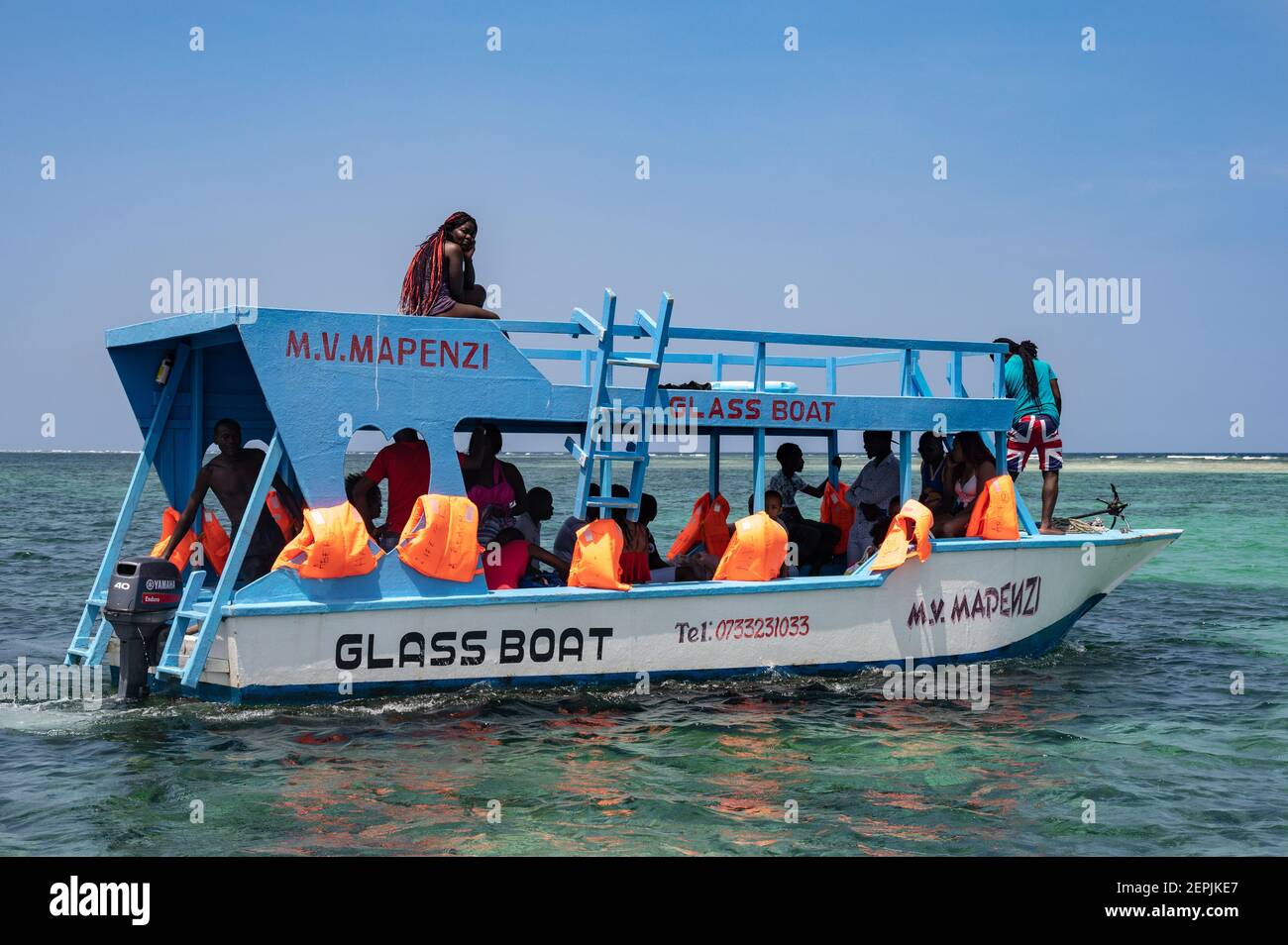 Touristes sur un bateau à fond de verre se dirigeant vers l'océan, Diani, Kenya Banque D'Images