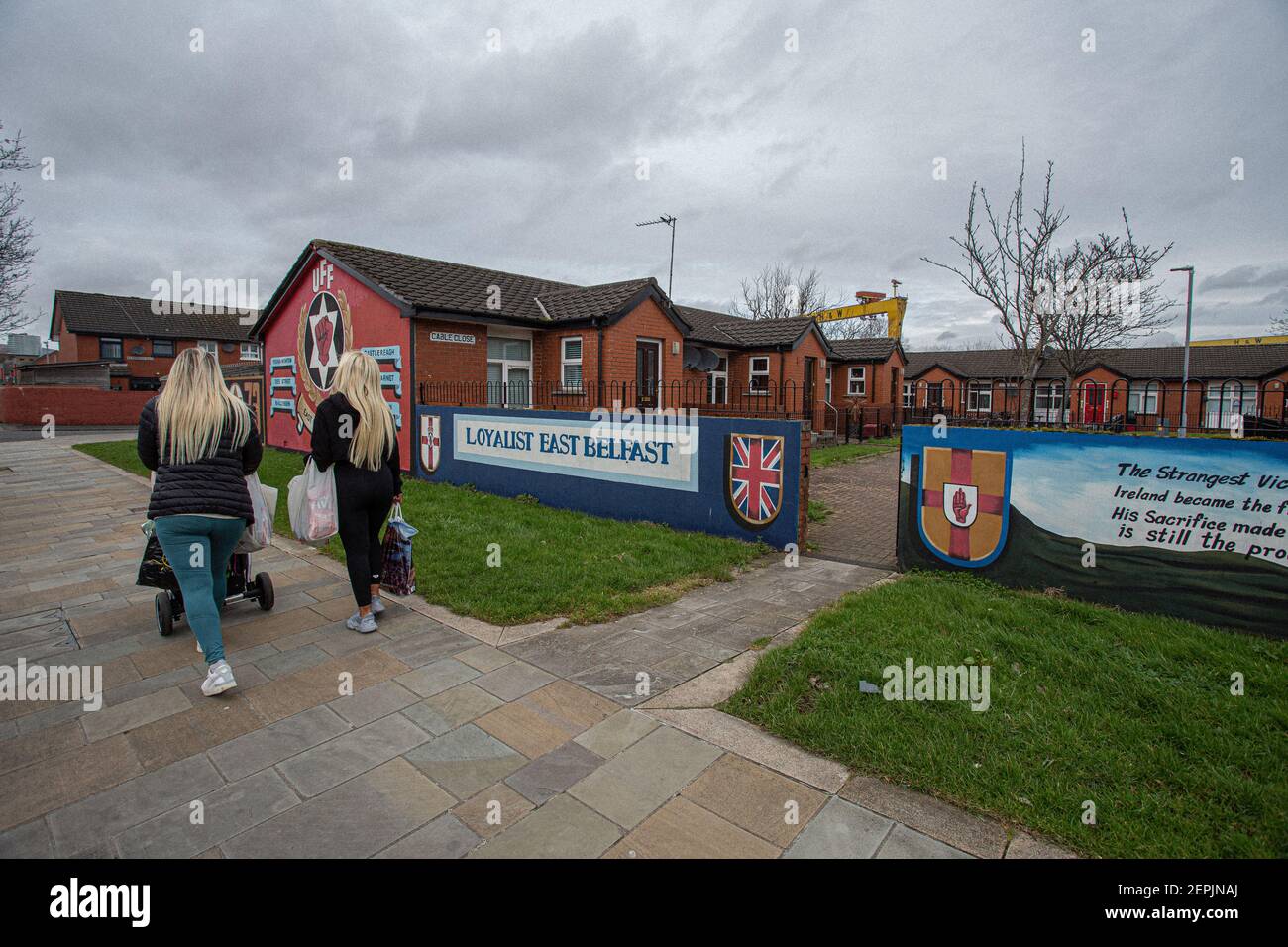BELFAST, IRLANDE DU NORD - février 24 : deux femmes passent devant des peintures murales loyalistes à 'Freedom Corner', Newtownards Road, Belfast. Banque D'Images