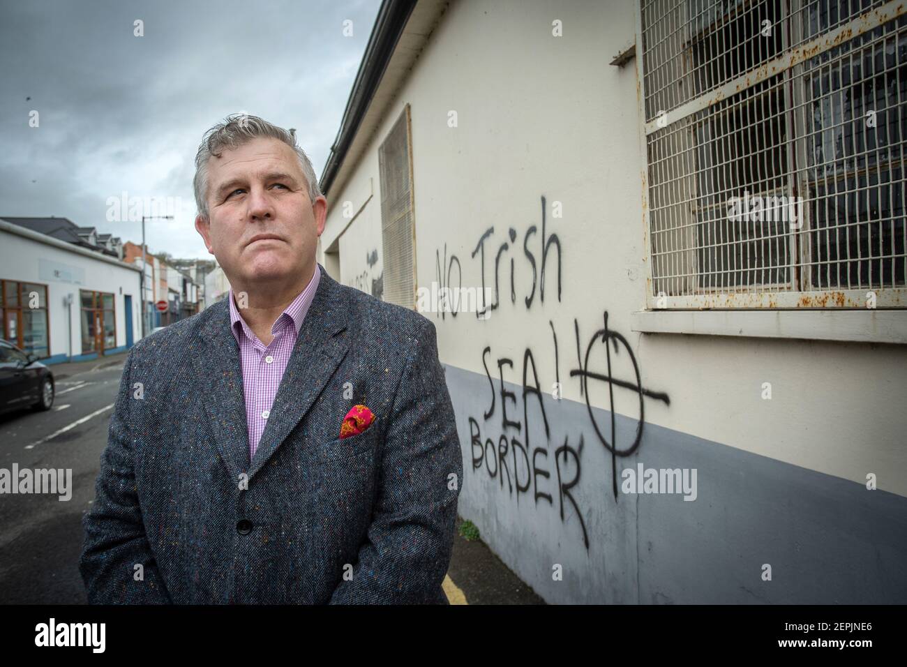 LARNE, IRLANDE DU NORD - février 24 : Keith Turner UUP devant des graffitis loyalistes menaçants destinés au personnel portuaire de Larne, dans le Nord Banque D'Images