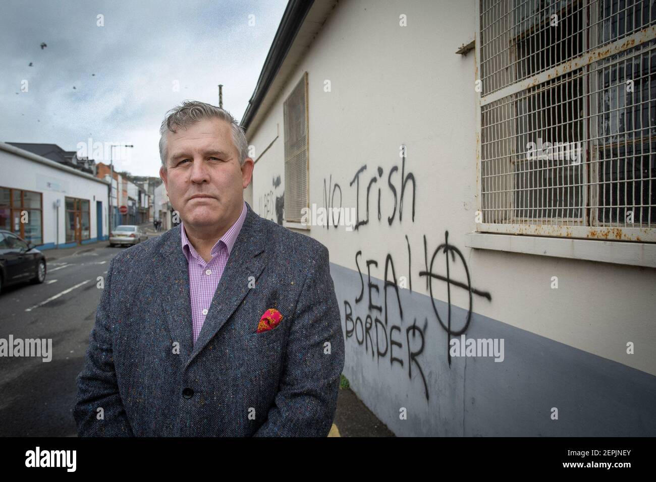 LARNE, IRLANDE DU NORD - février 24 : Keith Turner UUP devant des graffitis loyalistes menaçants destinés au personnel portuaire de Larne, dans le Nord Banque D'Images