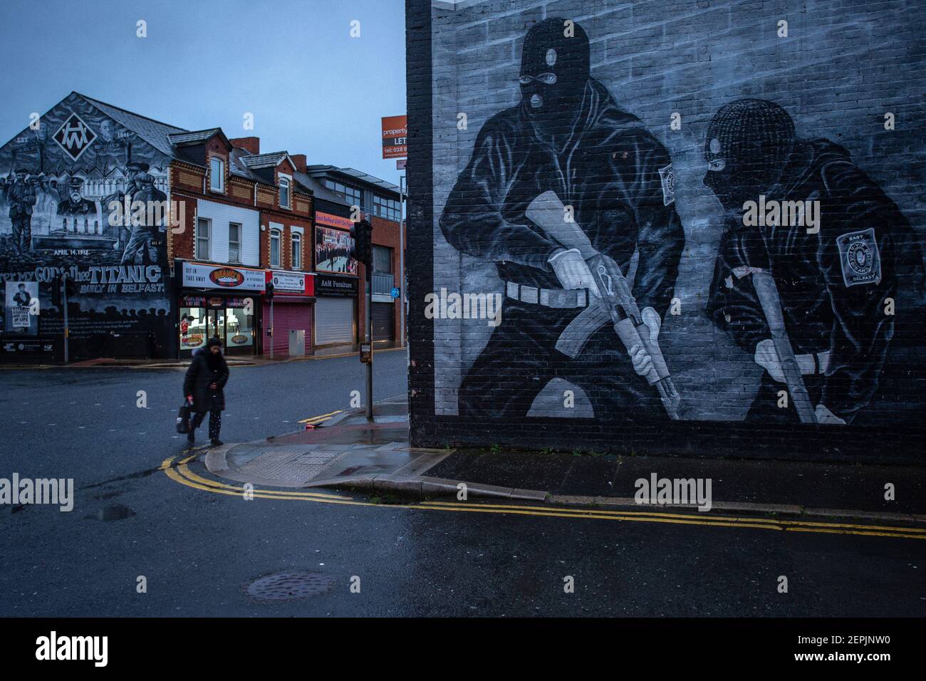 BELFAST, IRLANDE DU NORD - février 23 : une femme passe devant une murale paramilitaire loyaliste sur la route Newtownards le 23 février 2021 à Belfast. Banque D'Images