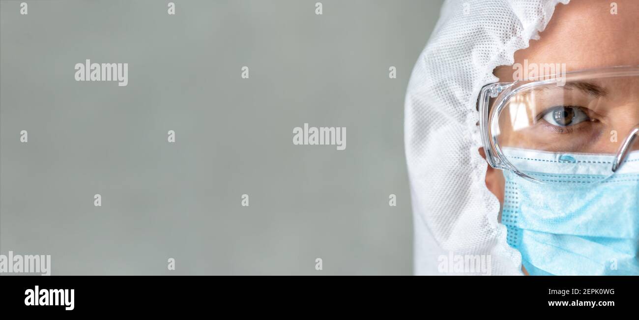 Médecin ou infirmière en costume d'EPI et contexte pour le texte, femme portant des lunettes de protection et un masque médical pour le visage en raison de la fermeture de la pandémie de coronavirus COVID-19 Banque D'Images