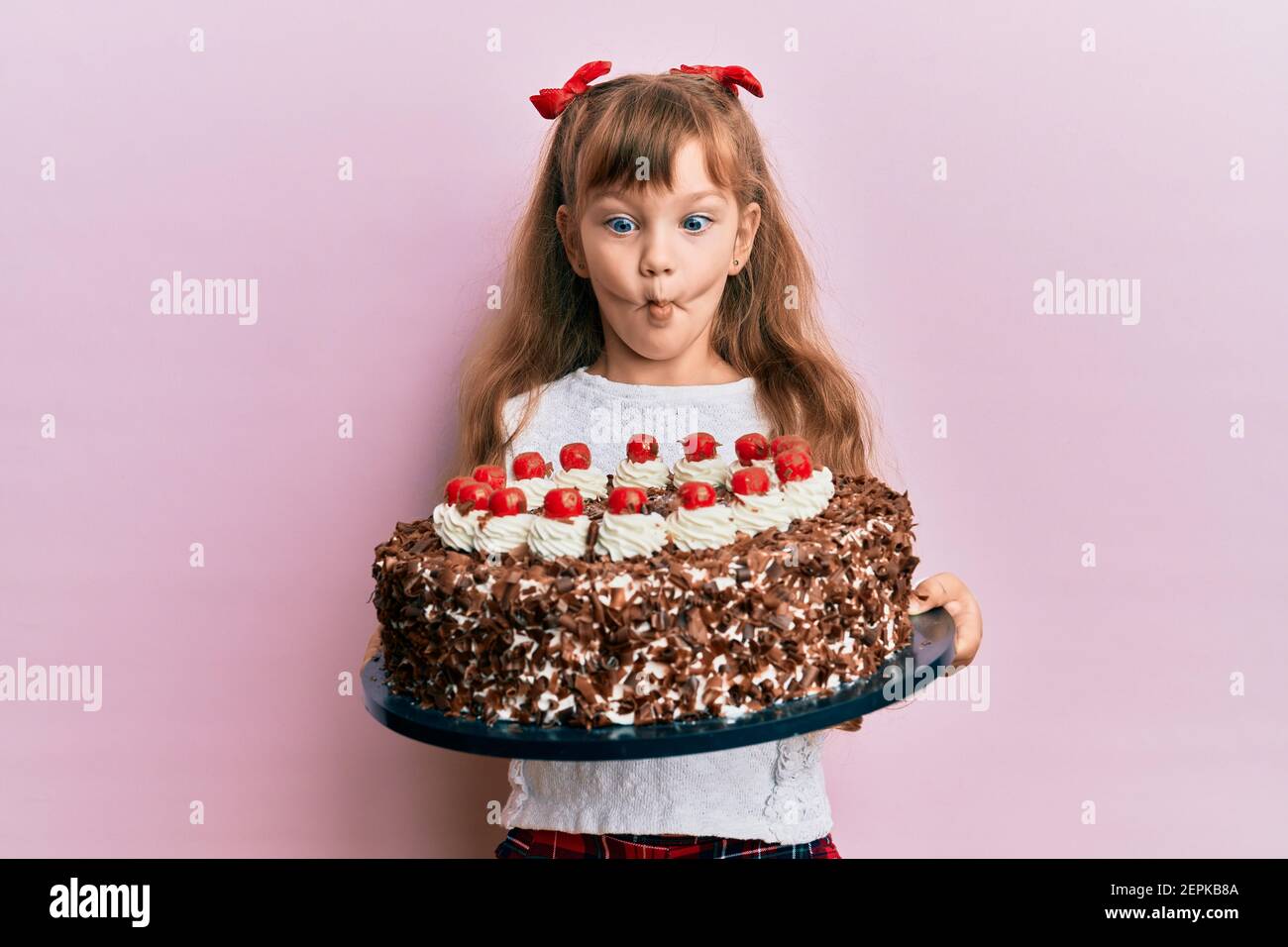 Petite Fille Caucasienne Fete Anniversaire Tenue De Gros Gateau De Chocolat Faire Le Visage De Poisson Avec La Bouche Et Les Yeux De Accroupi Fou Et Comique Photo Stock Alamy