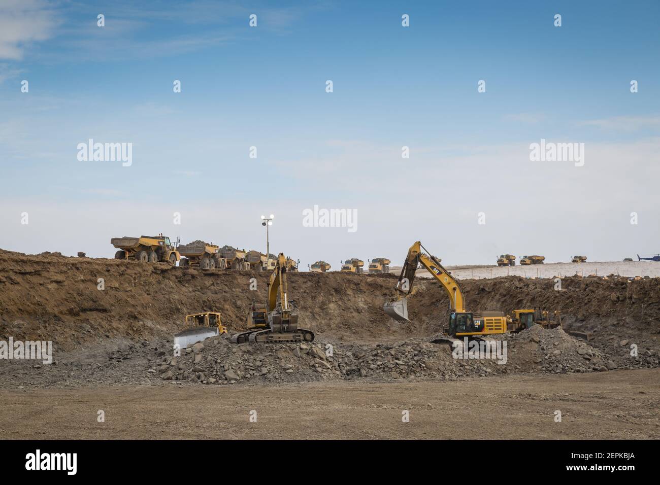 Camions transportant du gravier à partir de la mine de gravier utilisée pour construire la route Inuvik-Tuktoyaktuk, Territoires du Nord-Ouest, Arctique canadien (avril 2016) Banque D'Images