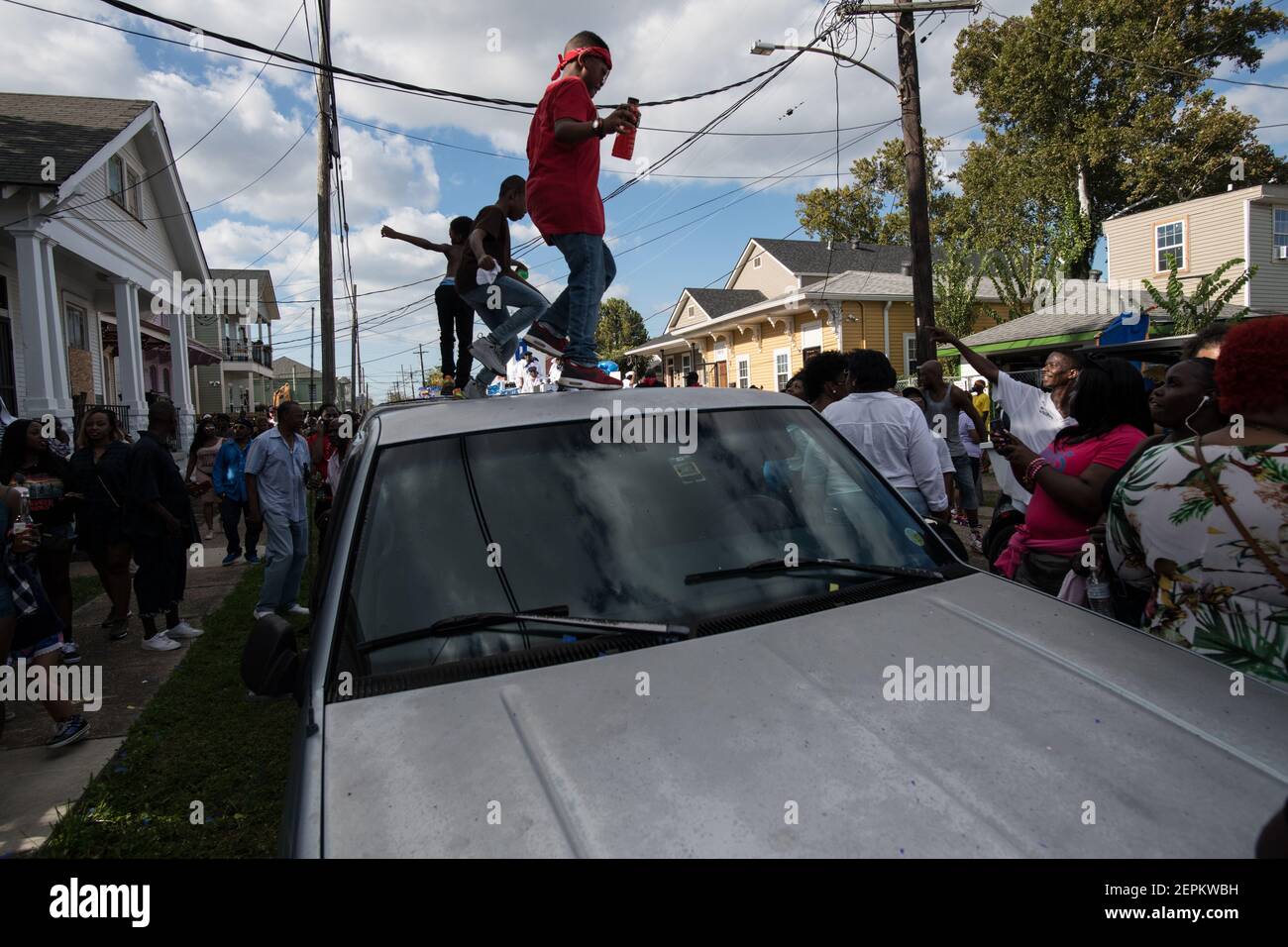 Les enfants dansent au sommet d'une voiture lors d'un défilé dynamique de deuxième ligne dans le quartier Treme de la Nouvelle-Orléans, mettant en valeur les riches traditions culturelles de la ville. Banque D'Images