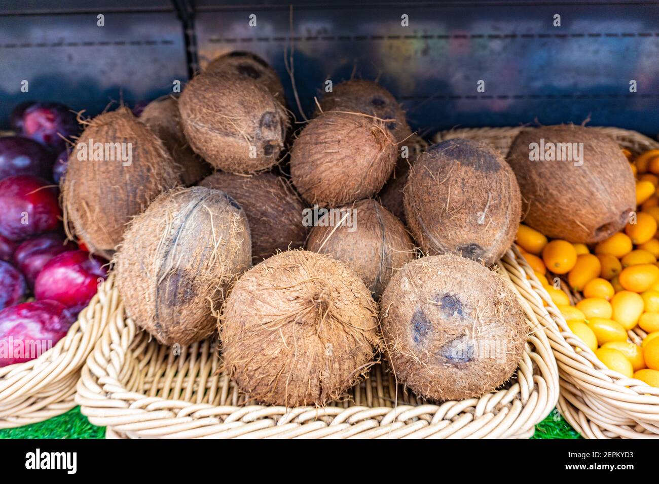 Les noix de coco récoltent dans le supermarché gros plan, bouquet de noix de coco dans des boîtes sur le marché Banque D'Images