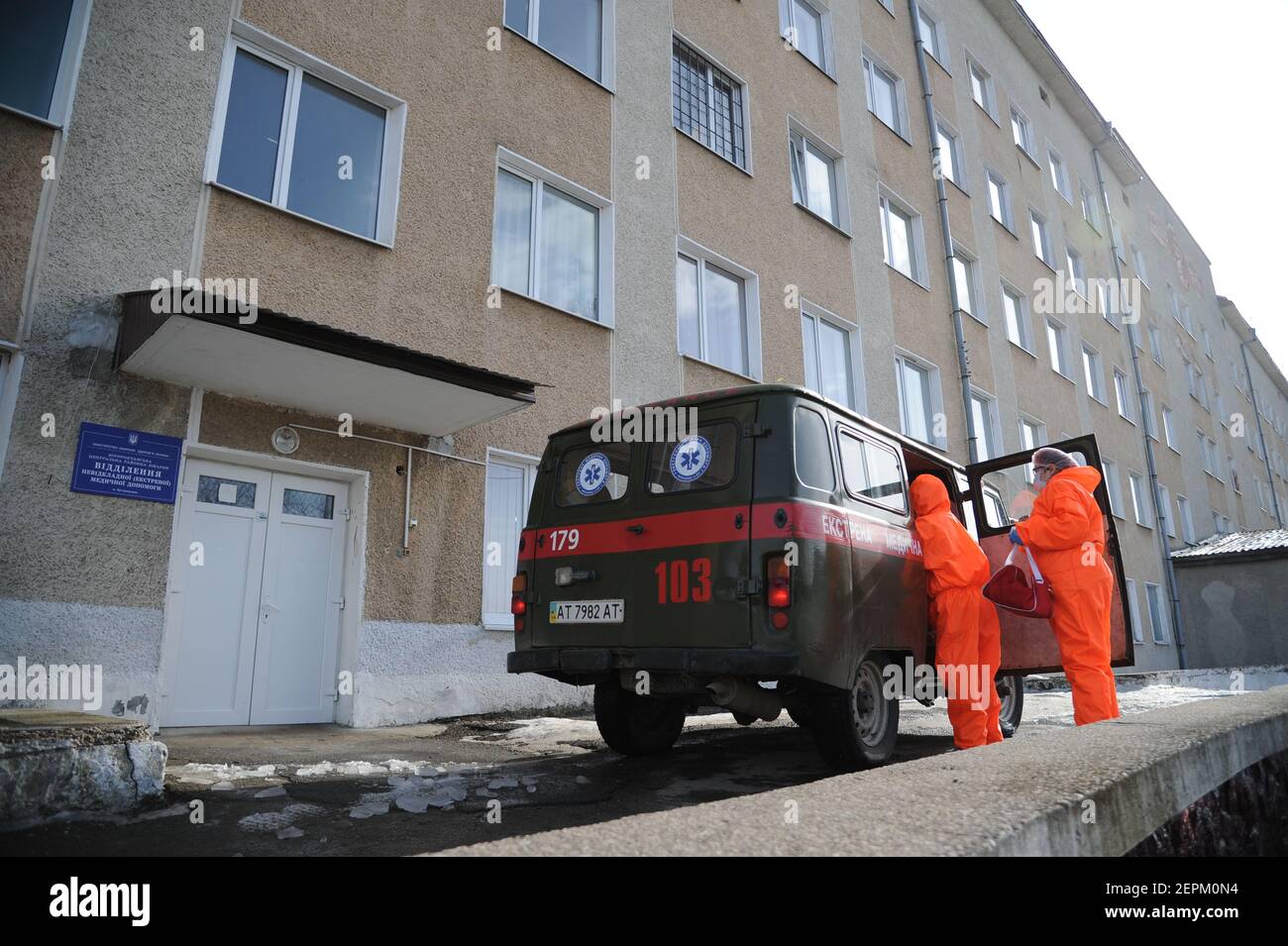 Deux travailleurs médicaux portant des combinaisons pour se protéger contre le coronavirus aident une femme âgée souffrant de COVID-19 à quitter une ambulance pour un hôpital à Bohorodchany, dans l'ouest de l'Ukraine. Après plusieurs retards, l'Ukraine a finalement reçu 500,000 doses du vaccin AstraZeneca commercialisé sous le nom de CoviShield, la première expédition de doses du vaccin Covid-19. L'Ukraine est l'une des dernières dans la région à commencer la vaccination de sa population. Banque D'Images