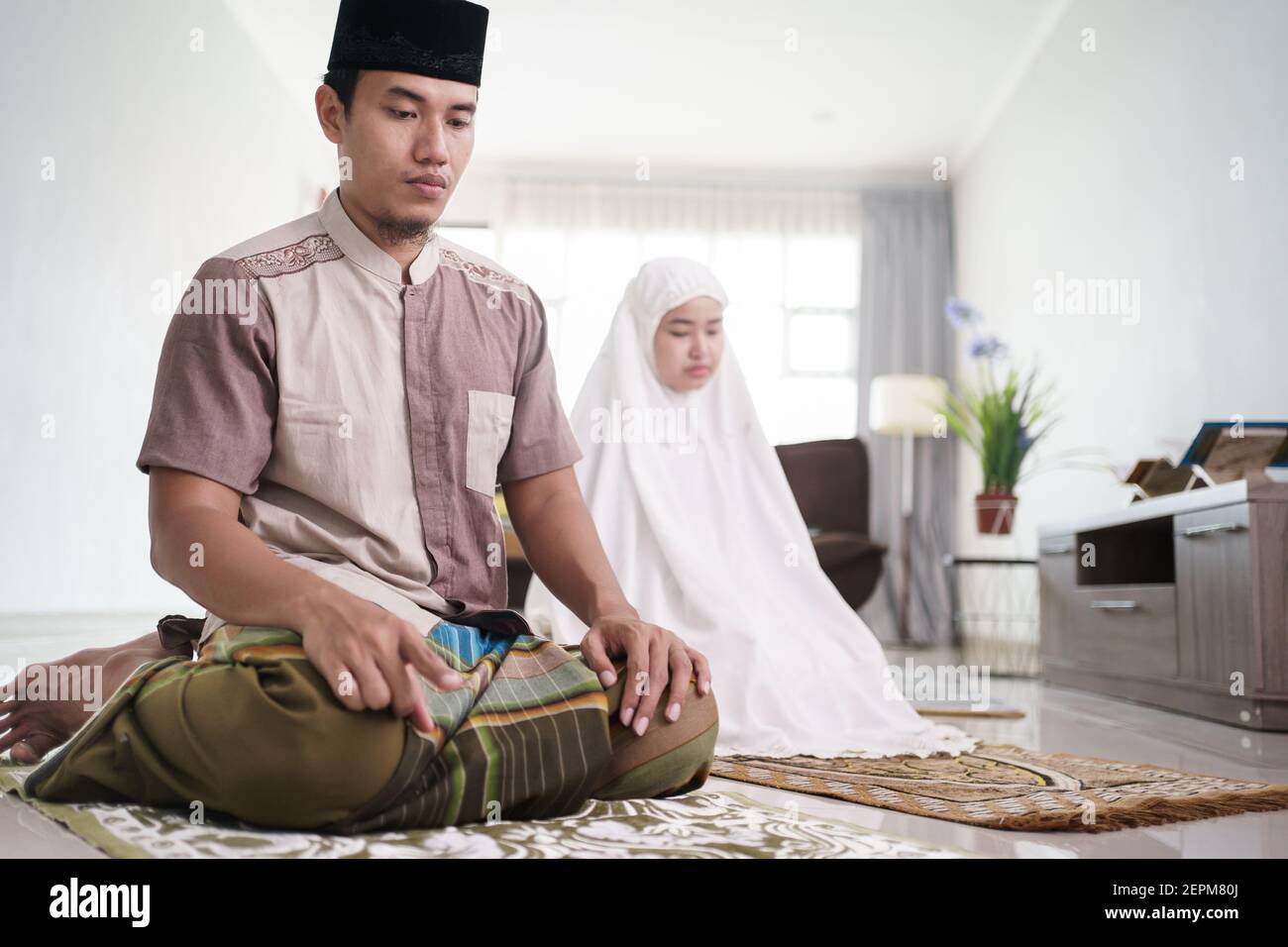 le mari et la femme musulmans d'asie prient la jamaah ensemble chez eux Banque D'Images
