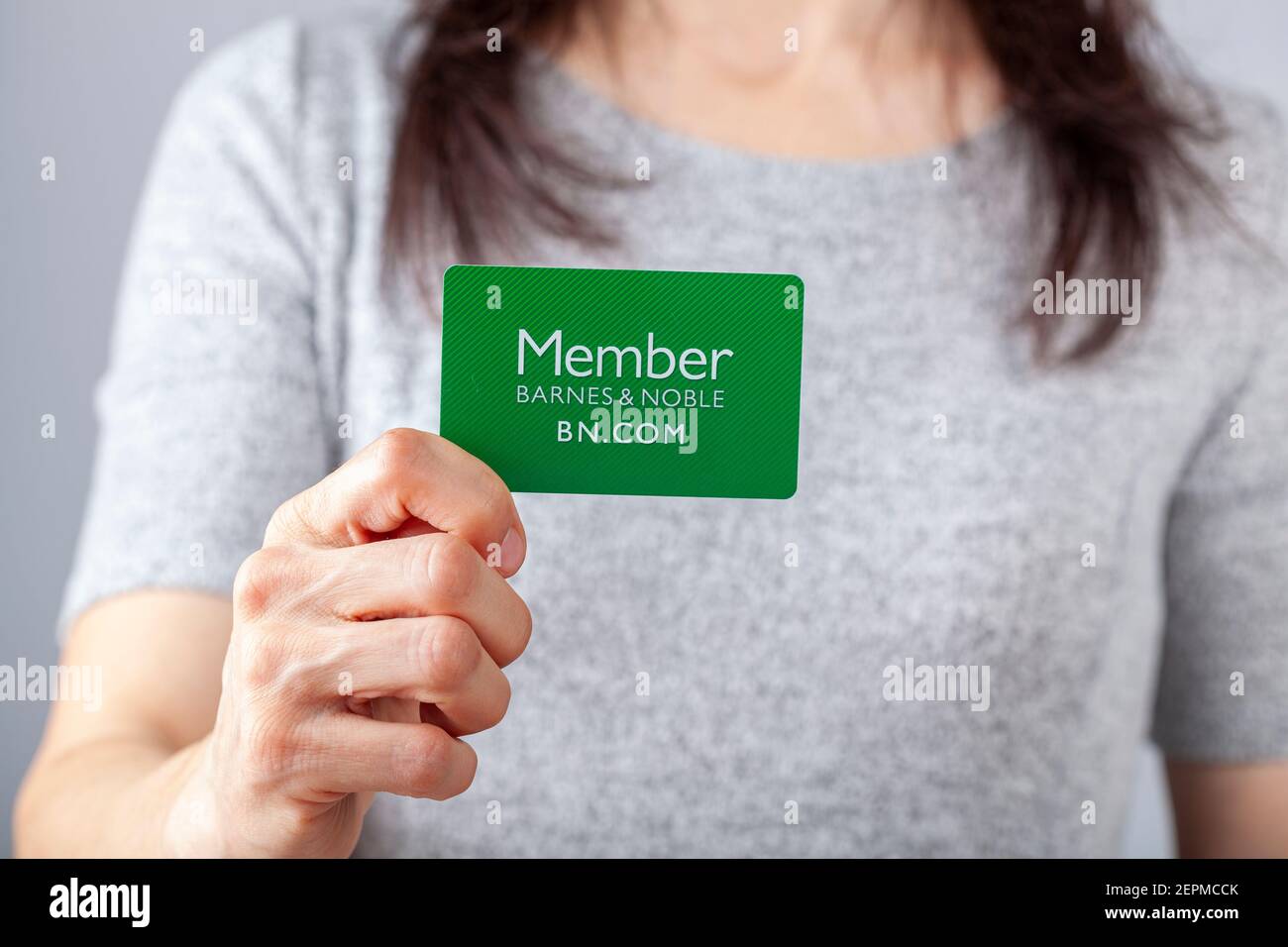 02-24-2021 Clarksburg, MD, États-Unis : une jeune femme caucasienne tient une carte verte qui dit membre Barnes and Noble. En tant que membre, membre du Banque D'Images