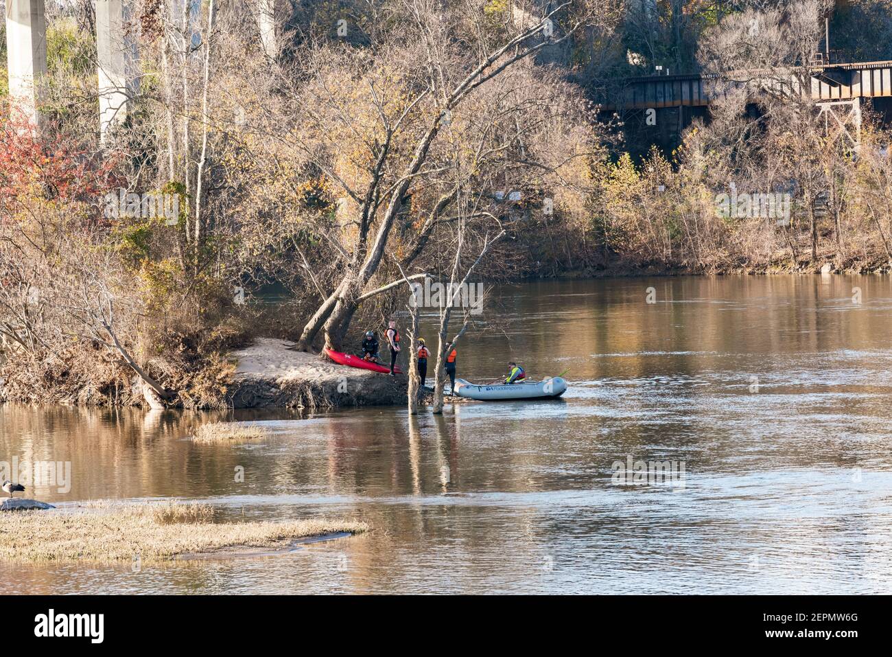 Les kayakistes font une pause sur les rives d'une île sur la rivière James à Richmond, va avec le trellis de cerveau parmi les arbres en arrière-plan. Banque D'Images