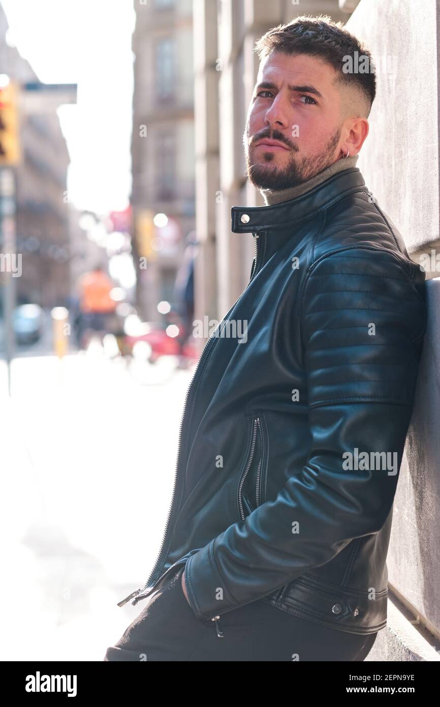 Jeune homme masculin taille basse en cuir veste penchée sur le mur et vue  sur la ville Photo Stock - Alamy