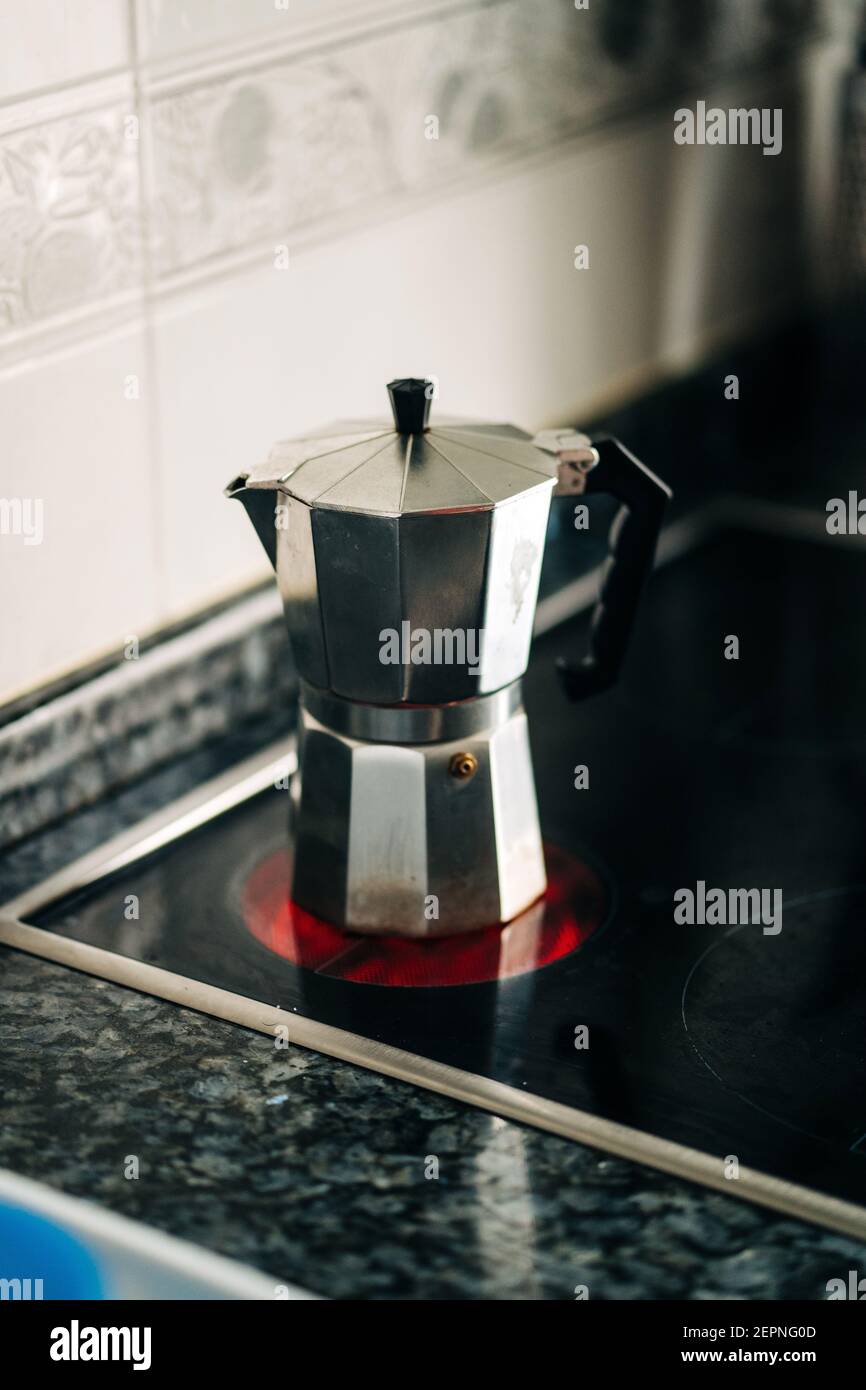 Cafetière avec plaque de cuisson en métal et poignée en plastique sur le moderne plaque chauffante dans la cuisine de la maison à la lumière du jour Banque D'Images