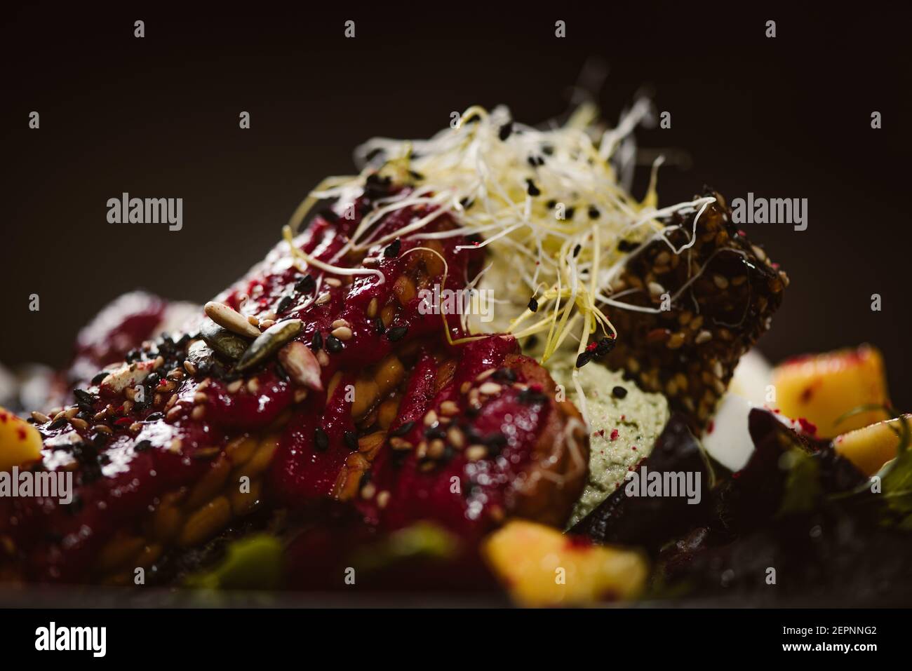 Vue rapprochée de l'assiette avec de savoureuses salades indonésiennes végétariennes avec des tranches de mangue fraîche et de fromage à la noix de cajou près du soja et condiments couverts de basi Banque D'Images